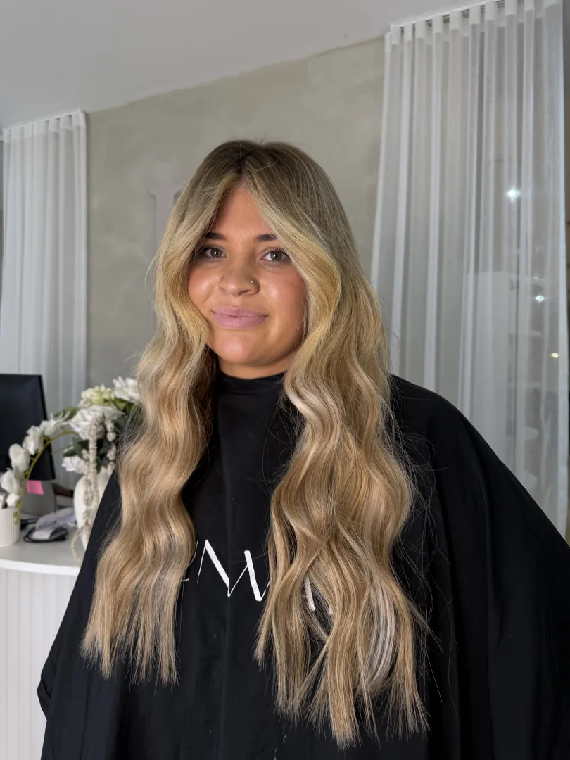 Long caramel blonde hair extensions with soft waves by a Runway stylist in Tamworth